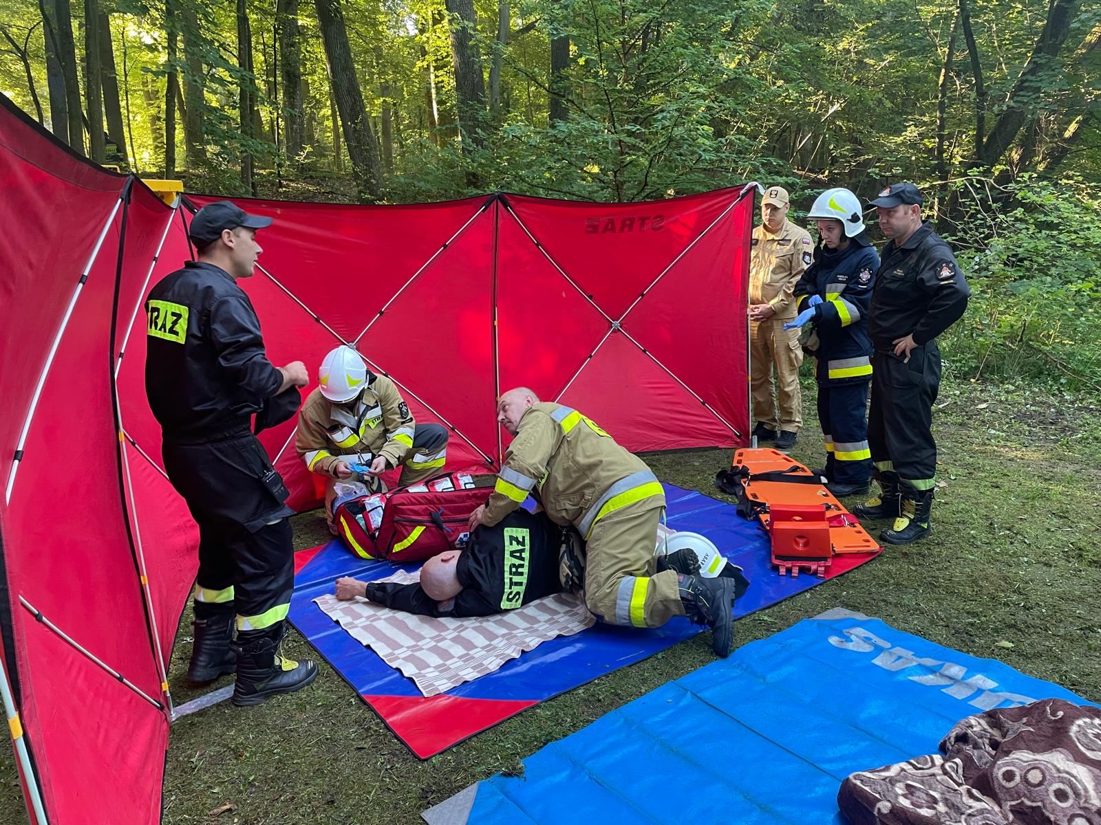 Wypadki nie omijają i strażaków Dwóch strażaków udziela pierwszej pomocy poszkodowanemu koledze