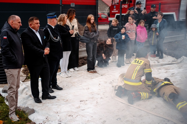 Strażacy wyciągają nieprzytomnego kolegę z zadymionego pomieszczenia