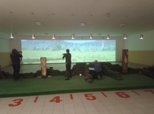 Grupa strzelców mierzących w stronę ekranu symulatora Snieżniek-2